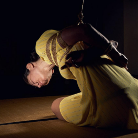 rope bottom woman sitting on tatami hands tied on the back leaning towards