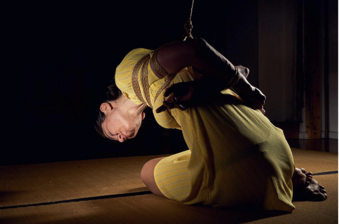 rope bottom woman sitting on tatami hands tied on the back leaning towards