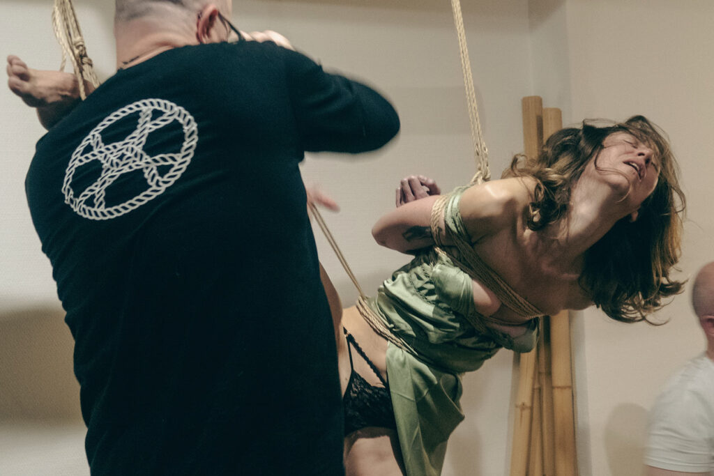 Rope bottom moving in response to a rigger during a Kinbaku session