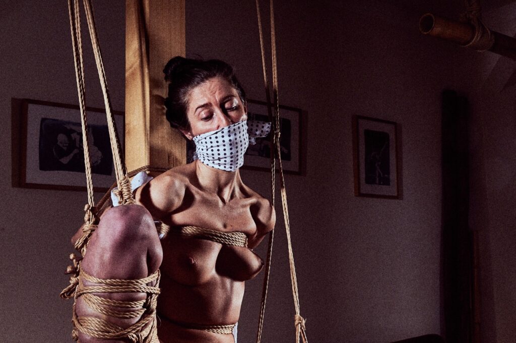 Rope bottom in a Kinbaku suspension with a futomomo leg tie